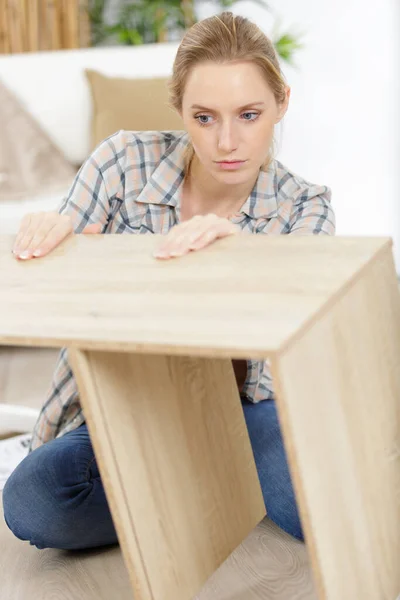 新しいアパートで家具を組み立てる若い女性は — ストック写真