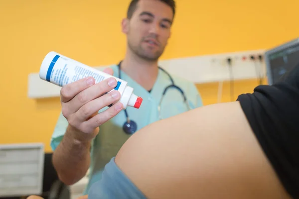 妊娠中の女性の腹に超音波ゲルを適用する医師 — ストック写真
