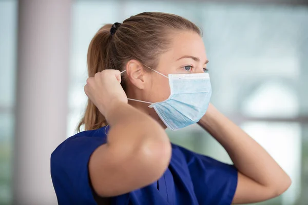 Female Nurse Puts Protective Face Mask — Stock Photo, Image