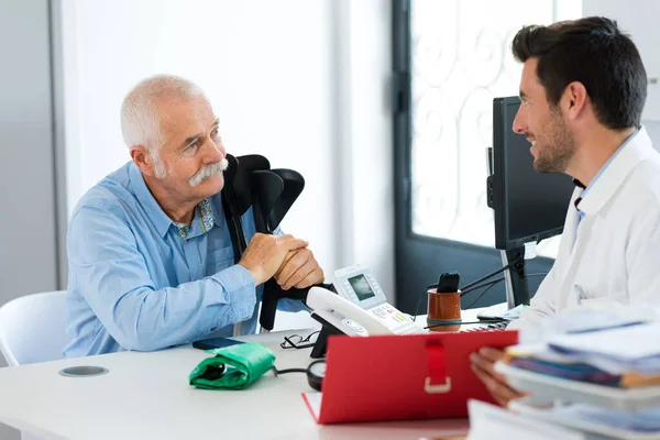 Starszy Mężczyzna Stać Rozmawiać Lekarzem Biurze — Zdjęcie stockowe