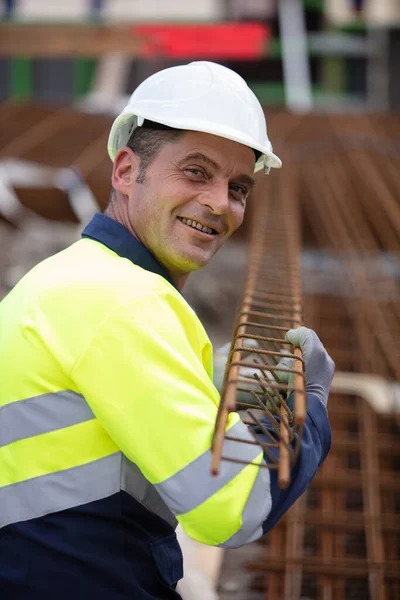 笑容满面的成熟建设者 携带基本金属托盘棒 — 图库照片