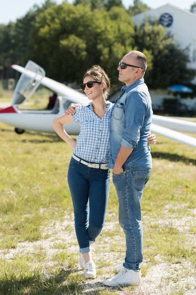 一对夫妇在滑翔机前摆姿势 — 图库照片