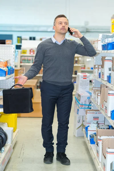 Hırdavatçıdaki Adam Akıllı Telefondan Konuşuyor — Stok fotoğraf