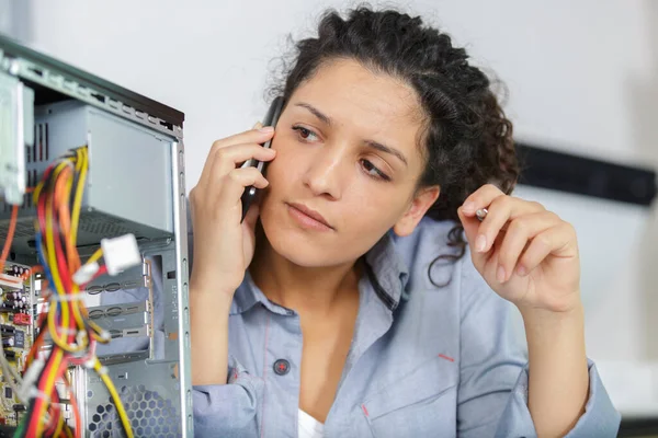 Γυναίκα Στο Τηλέφωνο Που Φτιάχνει Έναν Υπολογιστή Στη Δουλειά — Φωτογραφία Αρχείου