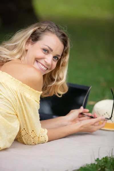 一个微笑的小女孩与笔记本电脑进行户外 — 图库照片