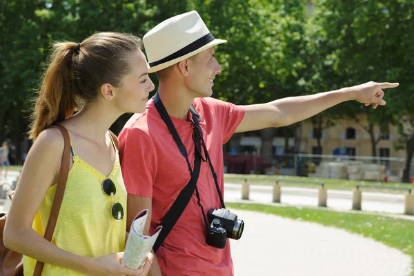 tourist couple in park pointing into distance