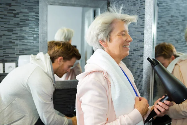 Ηλικιωμένη Γυναίκα Που Φυσάει Μαλλιά Της Στην Τουαλέτα Του Γυμναστηρίου — Φωτογραφία Αρχείου