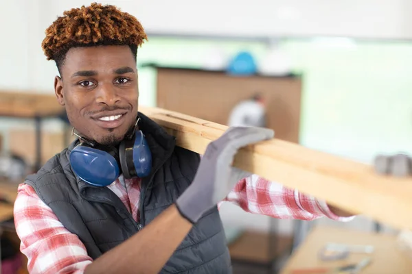 Junger Mann Handschuhen Trägt Holzbretter Auf Der Schulter — Stockfoto