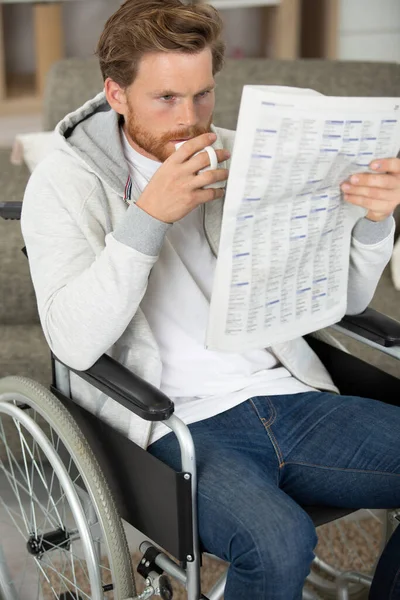 Улыбающийся Человек Инвалидной Коляске Пьет Чай Читает Газету — стоковое фото
