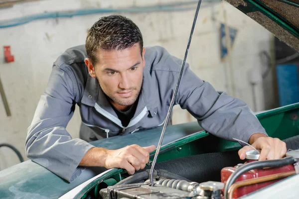 stock image Young mechanic looking at an engine