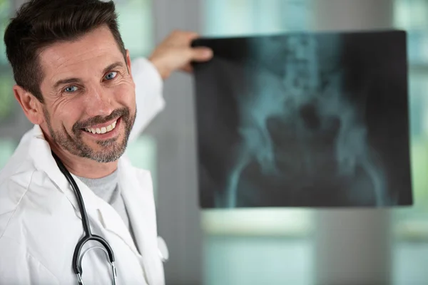 Médecin Attrayant Examinant Une Radiographie Souriant Caméra — Photo