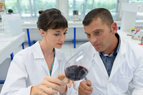 白コートの2人の研究者がワインの酸味を — ストック写真