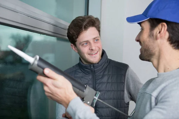 stock image men use silicone on a window