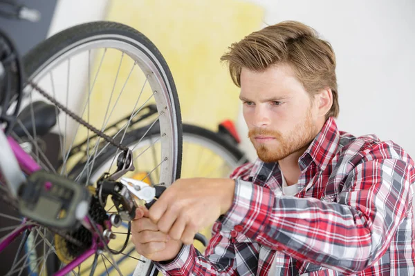 수리공 자전거 기어를 바퀴에 조절하는 — 스톡 사진