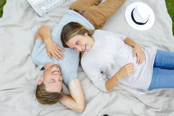 幸福的年轻夫妇躺在毛毯上的肖像 — 图库照片