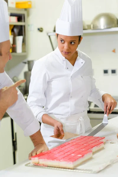 Female Confectionery Apprentice Slicing Cake — Stock Photo, Image