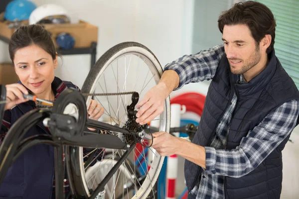 自転車に取り組む男性と女性の機械工は — ストック写真