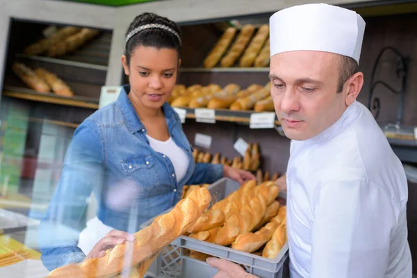 Piekarz Wprowadzenie Świeżo Upieczony Chleb Wystawę — Zdjęcie stockowe