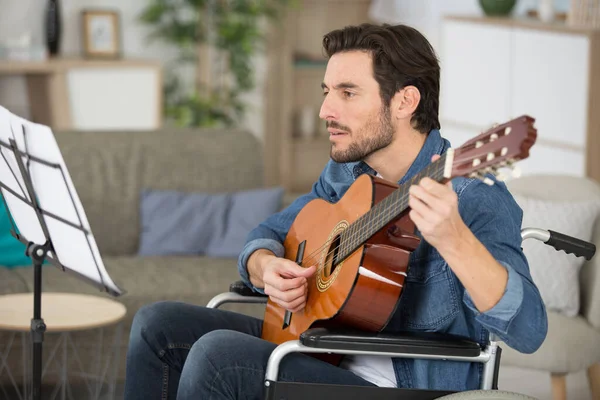 Mann Spielt Hause Gitarre Und Schaut Sich Notenblätter — Stockfoto