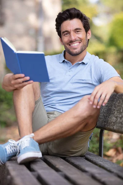 Yakışıklı Adam Bankta Oturmuş Kitap Okuyor — Stok fotoğraf