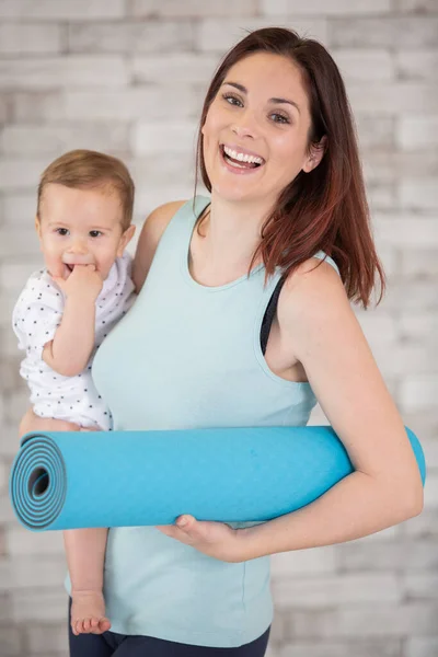 Glad Kvinna Håller Baby Och Träningsmatta — Stockfoto