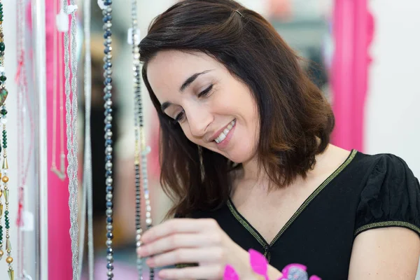 Szczęśliwa Kobieta Patrząc Naszyjniki — Zdjęcie stockowe