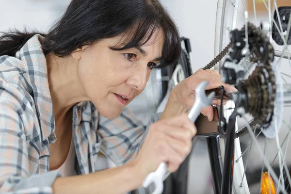 自転車修理工場で働く女性は — ストック写真