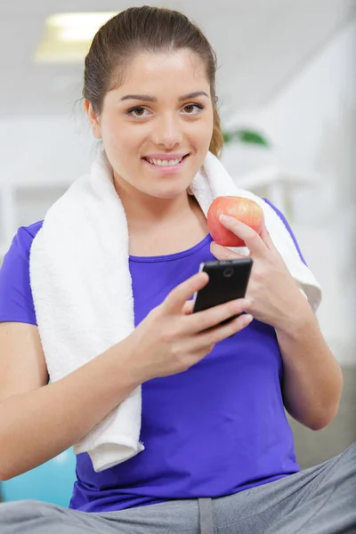 Donna Che Utilizza Telefono Cellulare Con Attrezzature Sportive Frutta — Foto Stock