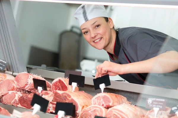 Uśmiechnięta Kobieta Rzeźnik Etykietowanie Stawów Mięsa Liczniku — Zdjęcie stockowe