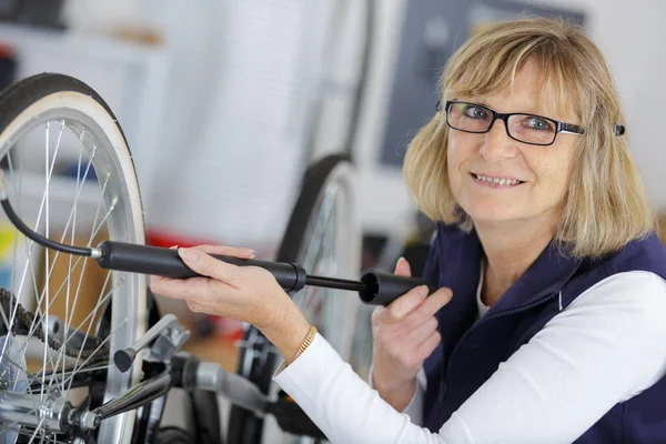 Kobieta Mechanik Mocujący Rower Warsztacie — Zdjęcie stockowe