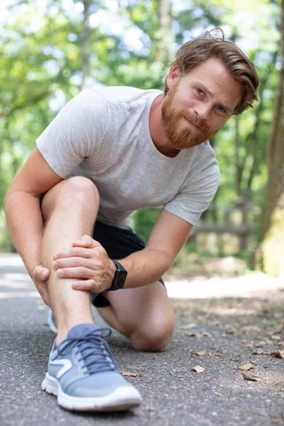男性ランナーには足のけいれんがあります — ストック写真