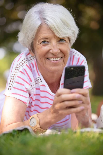 Senior Woman Using Smartphone Laid Grass Park — Stock Photo, Image