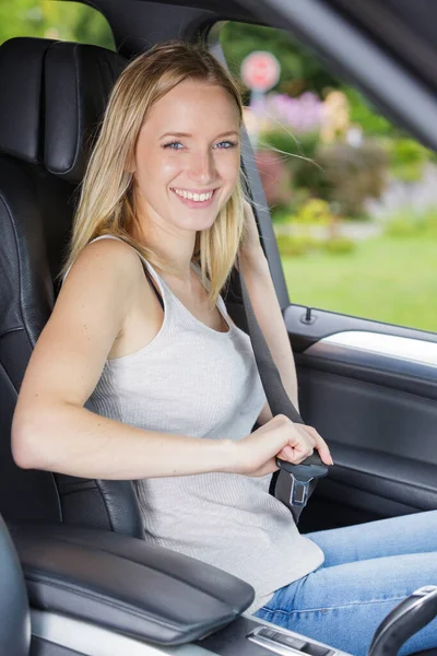 漂亮的年轻快乐的女人把安全带系在车上 — 图库照片