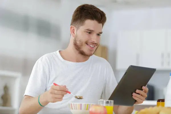 Mężczyzna Tabletem Komputer Jedzący Śniadanie Domu — Zdjęcie stockowe