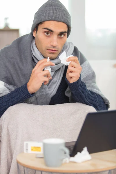 利用笔记本电脑在沙发上工作的年轻人 — 图库照片