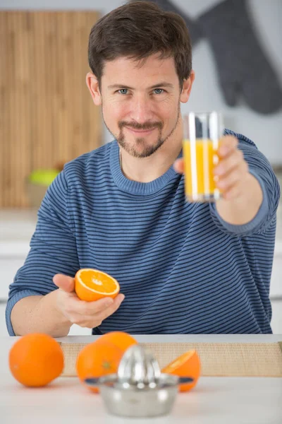 Mladý Muž Pije Pomerančový Džus — Stock fotografie