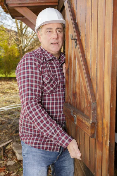 Budowniczy Montujący Drewniane Drzwi Zewnątrz — Zdjęcie stockowe
