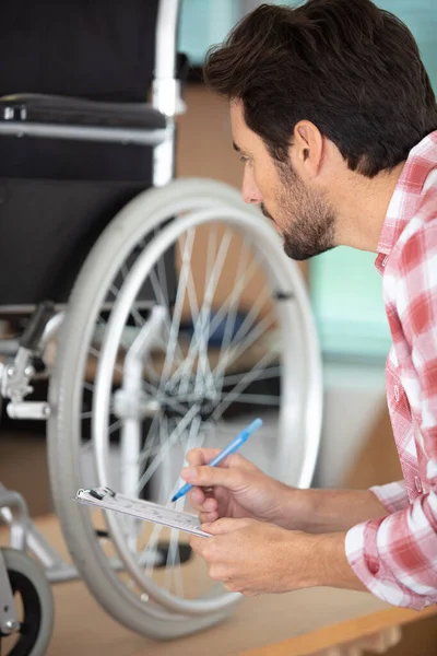 Genç Adam Tekerlekli Sandalye Tamir Ediyor — Stok fotoğraf