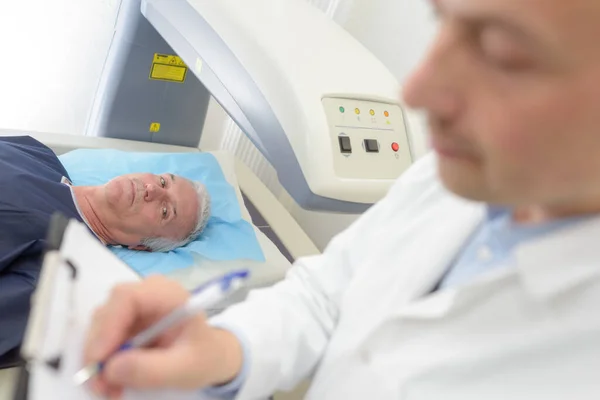 Doctor Writing Notes Patient Scanner — Stock Photo, Image