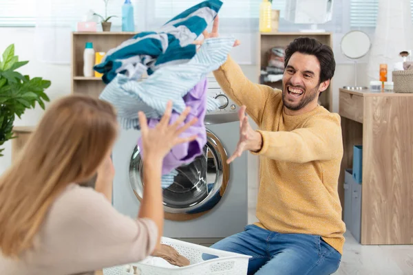 洗濯をしながら遊んでいる若いカップルは — ストック写真