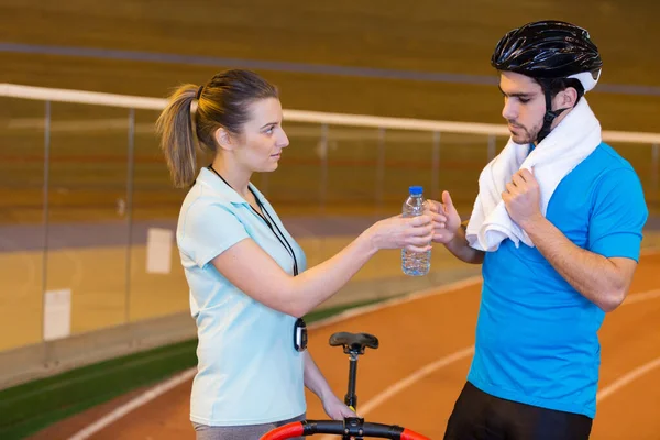 Kvinnlig Tränare Passerar Vatten Till Manliga Cyklist — Stockfoto