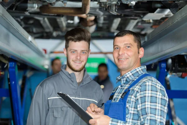 Dwóch Mechaników Pracujących Nad Samochodem — Zdjęcie stockowe