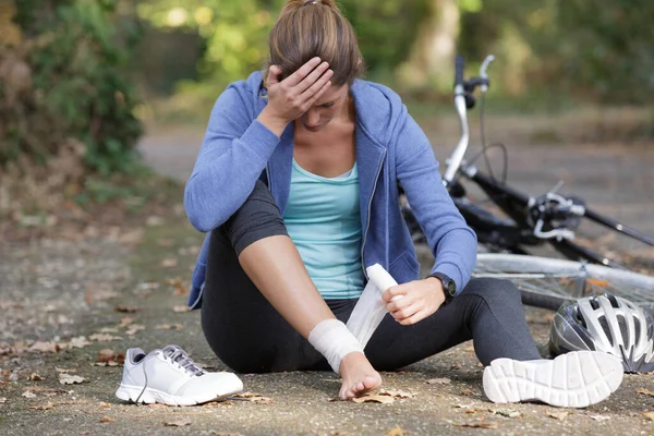 Frau Bandagiert Knie Nach Sturz Vom Fahrrad — Stockfoto