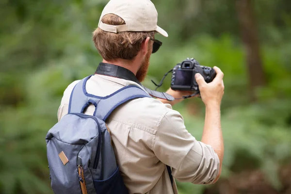 Οπίσθια Όψη Του Αρσενικού Backpacker Χρήση Κάμερας Αγροτικό Περιβάλλον — Φωτογραφία Αρχείου
