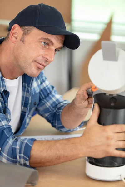 man repairing broken coffee machine