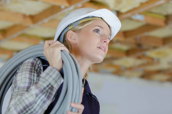 天井に換気を設置する女性電気技師は — ストック写真