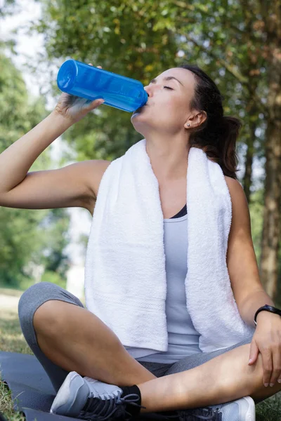 女性は森の中で水を飲む — ストック写真