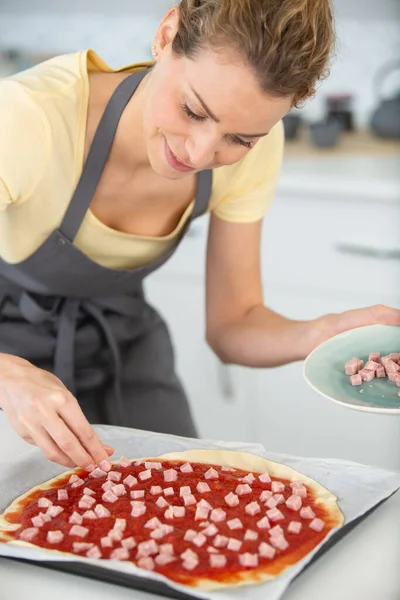 Vrouw Sprinkling Ham Topping Zelfgemaakte Pizza — Stockfoto