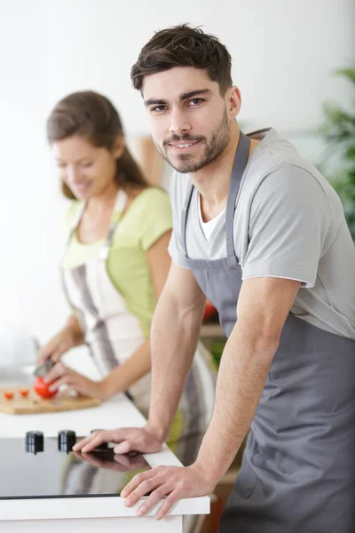キッチンで若いカップル料理の笑顔 — ストック写真