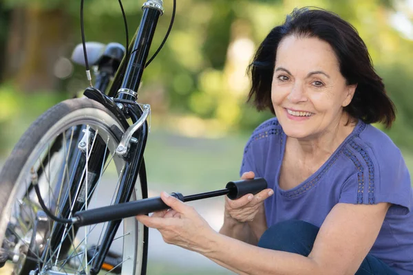 Mulher Sênior Infla Pneu Bicicleta — Fotografia de Stock